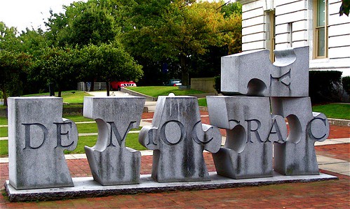 Puzzle piece sculpture saying democracy.