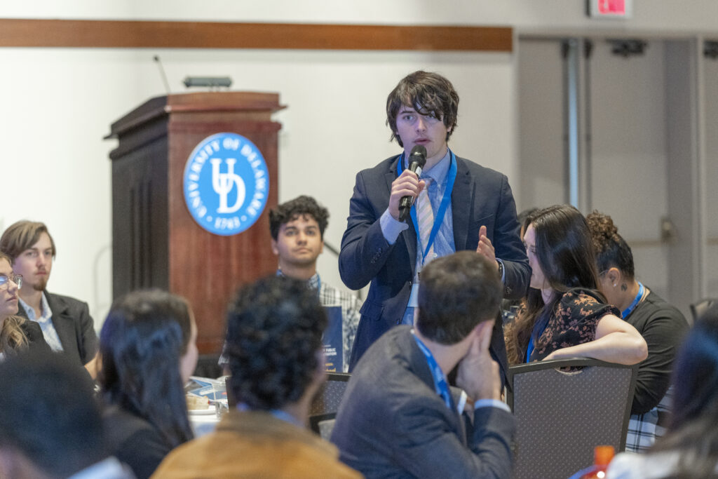 Photo of student speaking at conference.