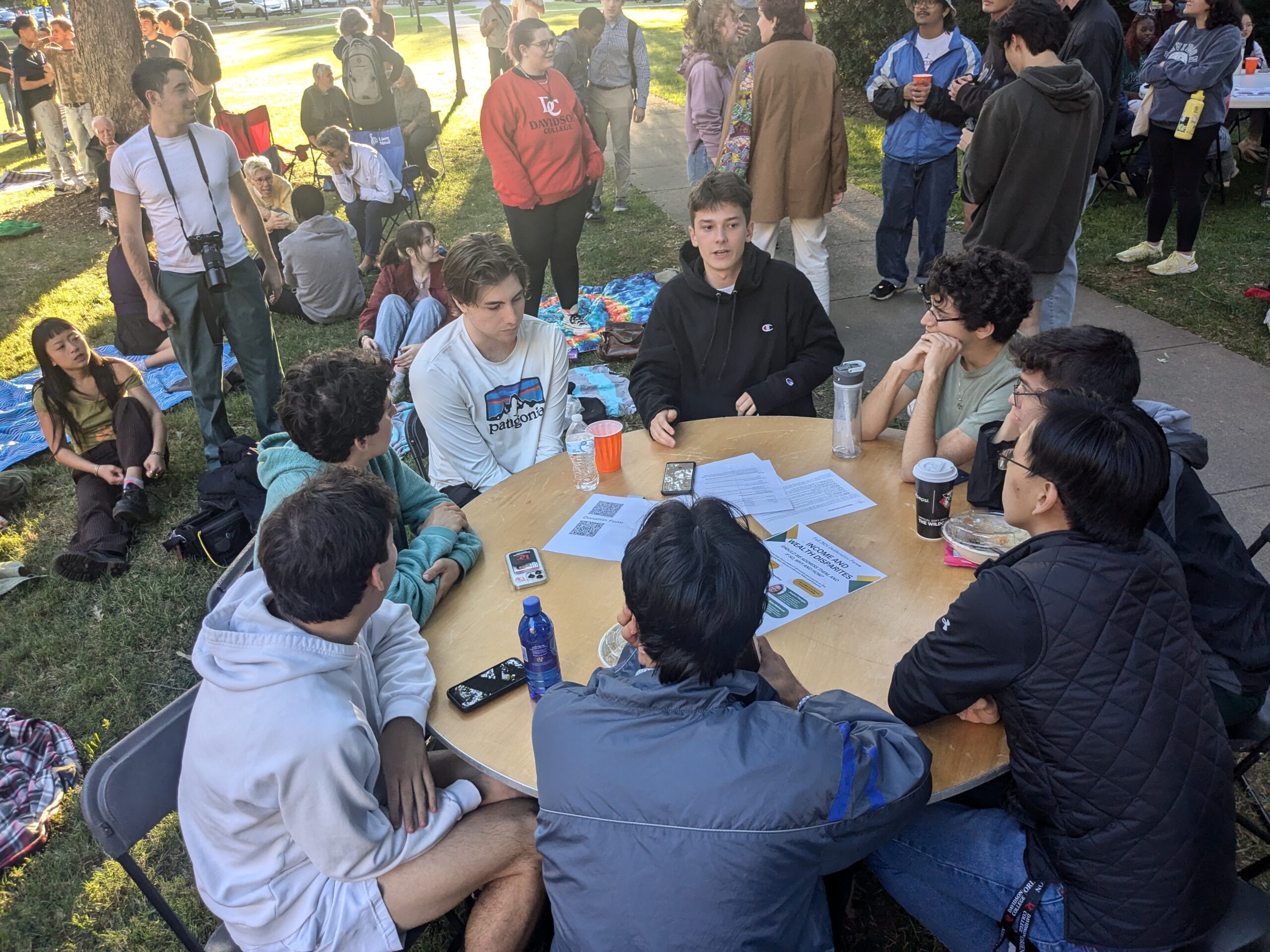 Group of students talking around a table.