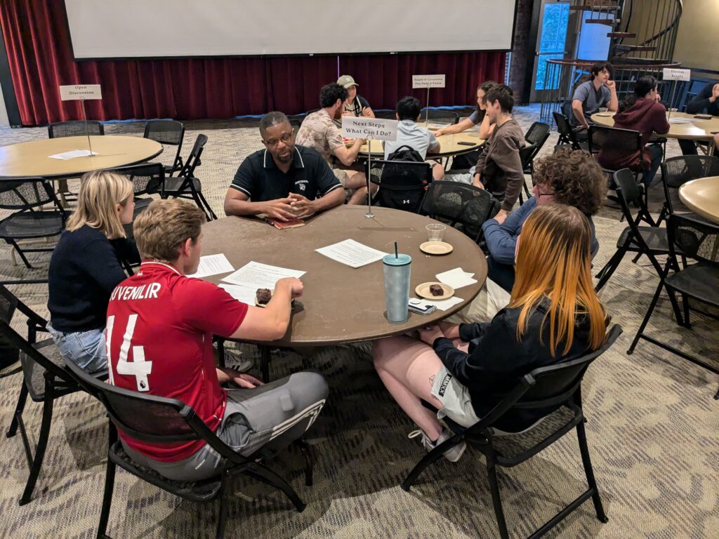 Students and Professor Bailey discussing around tables