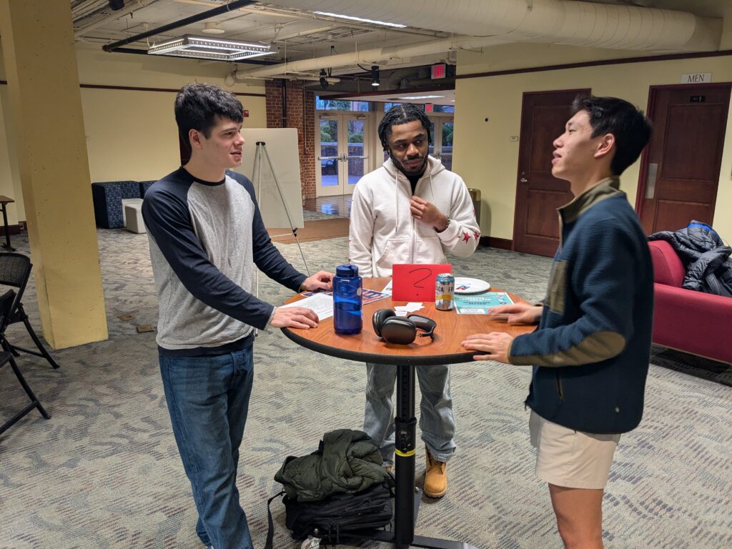 group of three people eating pizza and talking