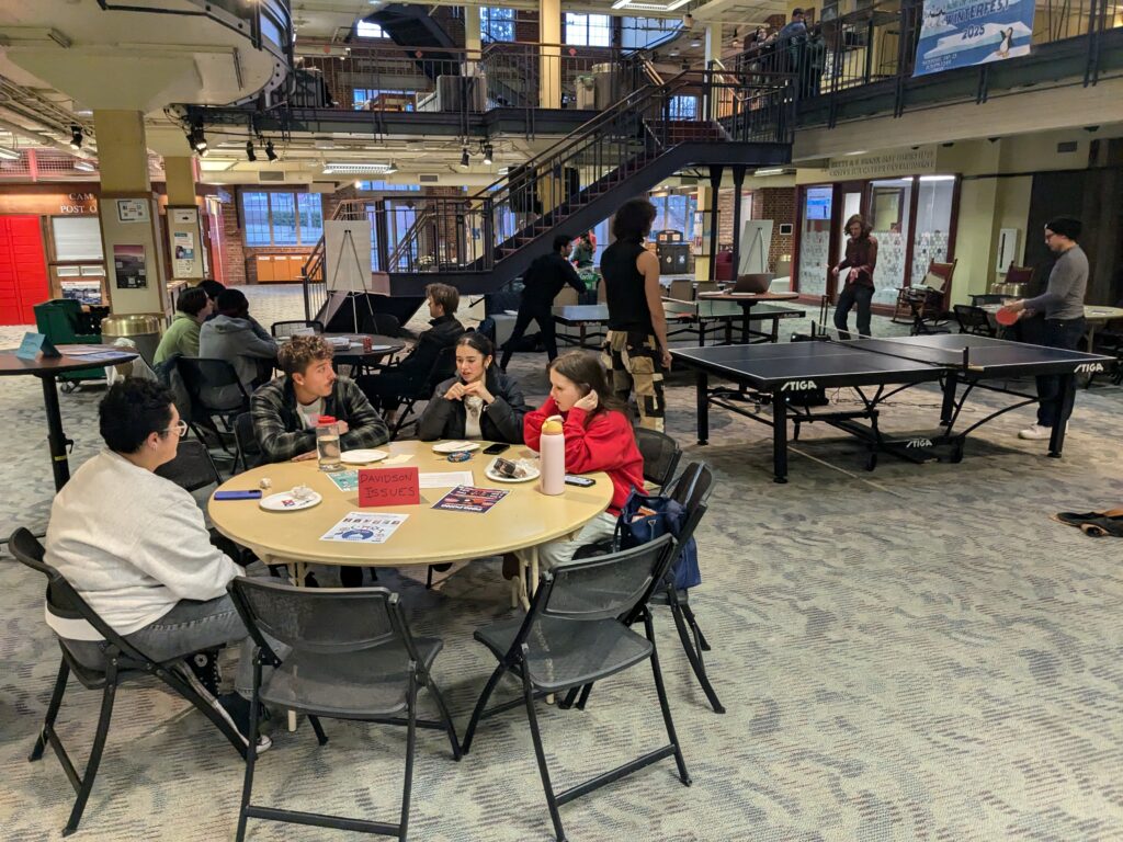 tables of people talking and playing ping pong