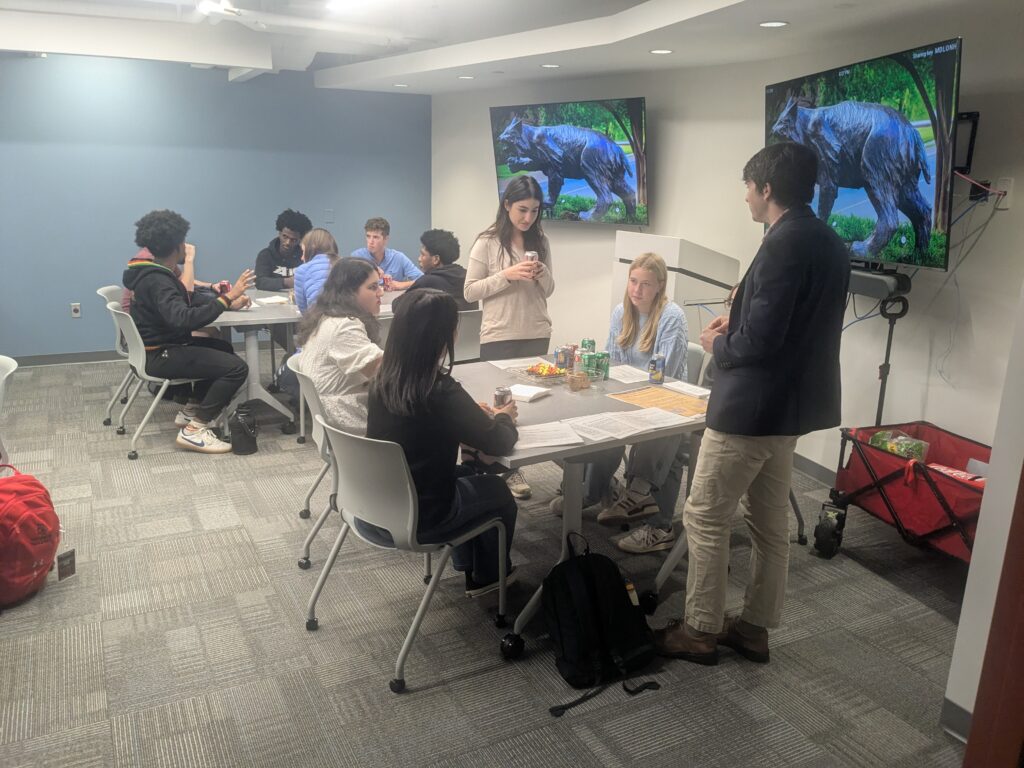 Two tables of deliberators with two facilitators standing