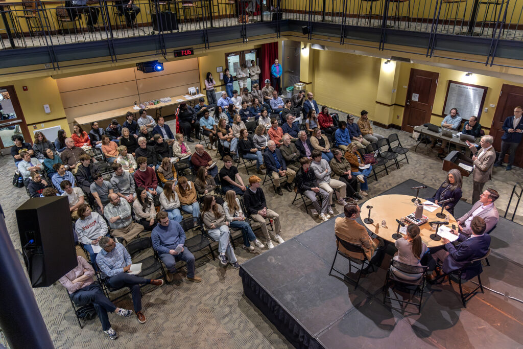 Photo of audience and roundtable with Graham Bullock speaking at podium