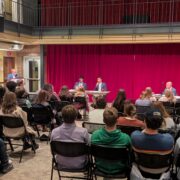 Photo of debaters sitting at tables