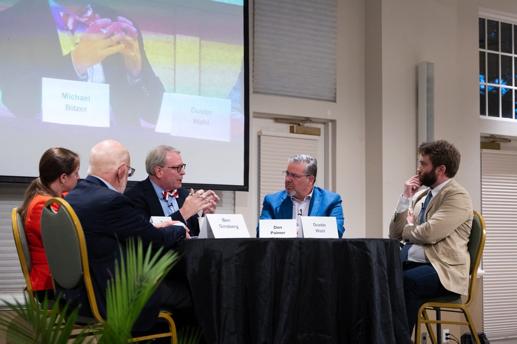 Panelists seated on stage around a table during the Deliberative Citizenship Initiative's "The Future of Elections" forum.