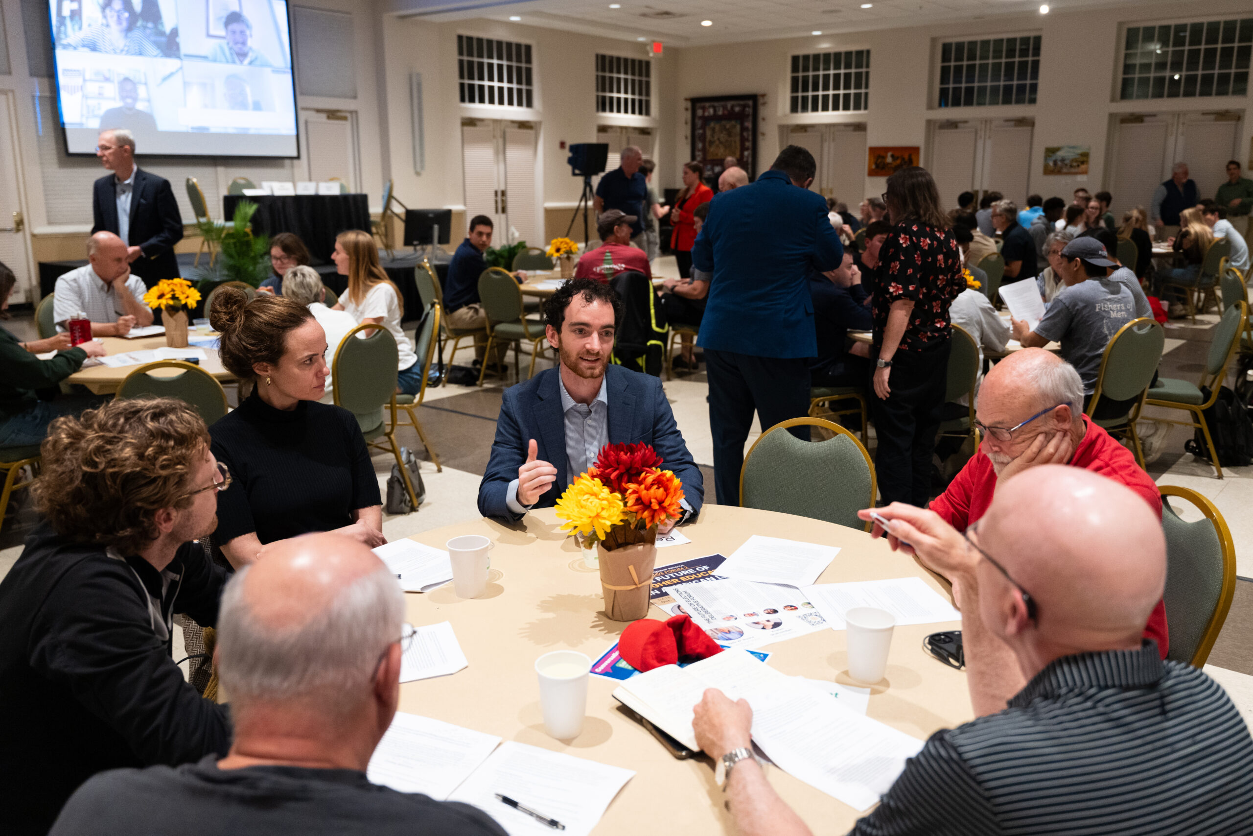 Participants seated around a round table engaged in discussion during a Deliberative Citizenship Initiative (DCI) deliberative forum.