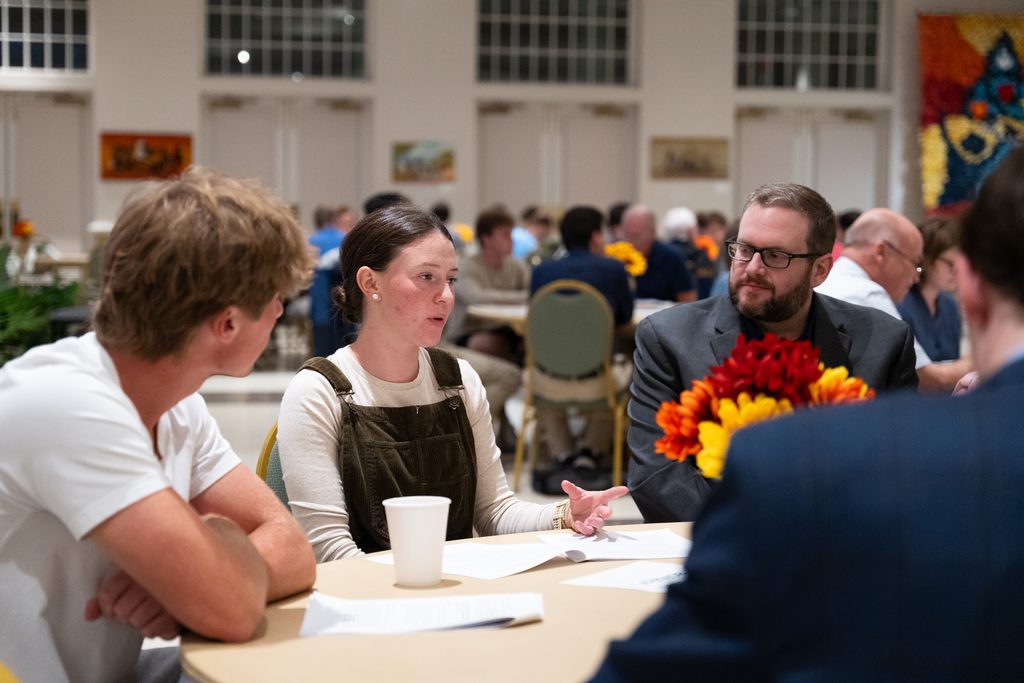 Participants engaged in a small-group discussion around a round table during a Deliberative Citizenship Initiative (DCI) event.